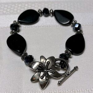 Beaded bracelet with unique flower clasp. Clasp closure is Silvertone.